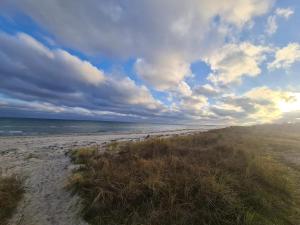 Una playa con cielo nublado y el océano. en Beachside Haven in Marielyst - By Traum Ferienwohnungen, en Bøtø By