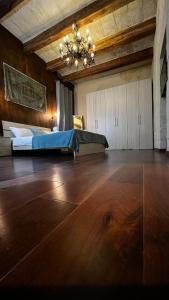 a large bedroom with a bed and a chandelier at De Rohan Central Townhouse 38 in Taʼ l-Infetti