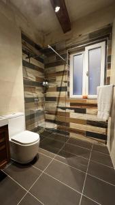a bathroom with a toilet and a glass shower at De Rohan Central Townhouse 38 in Taʼ l-Infetti