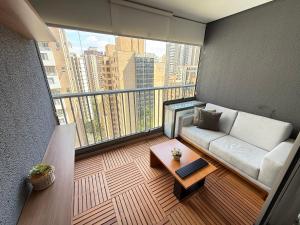 a living room with a couch on a balcony at On Jurupis in Sao Paulo