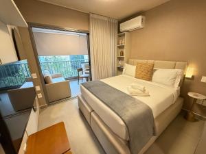 a bedroom with a large bed and a balcony at On Jurupis in Sao Paulo