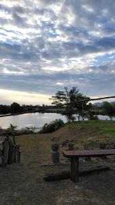 een bank naast een waterlichaam bij Soyak Senja Roomstay in Langkawi Intl