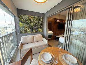 a living room with a table and a couch at On Jurupis in Sao Paulo