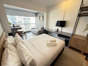 a bedroom with a large bed and a living room at On Jurupis in Sao Paulo