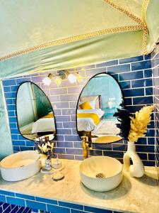 a bathroom with two mirrors and a sink and a bed at iMei Lux Camp 爱梅野奢营地 in Lac Yasmins