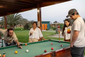 a group of people standing around a pool table at Casa Andina Standard Chincha in Chincha Alta