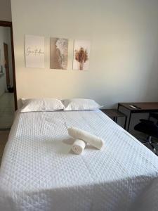 a white bed with a roll of toilet paper on it at Kitnet - Centro - Ipatinga in Ipatinga