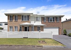 a house with a white fence in front of it at Haus on Moore in Oak Flats