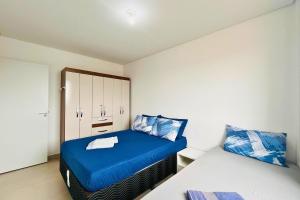ein kleines Schlafzimmer mit einem blauen Bett und einem Schrank in der Unterkunft Captiva Beach - 400m da PRAIA - WiFi - Vaga Coberta in Navegantes