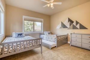 two beds in a bedroom with a ceiling fan at Beautiful Bend Retreat - Meredith Lodging in Bend +52 photos