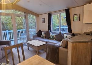 a living room with a couch and a table at The Treehouse Northumberland in Swarland