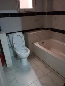 a bathroom with a toilet and a bath tub at MAISON Khadija Abibatou in Dakar +26 photos