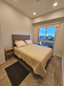 a bedroom with a large bed with a large window at Dpto excelente ubicación in Asuncion