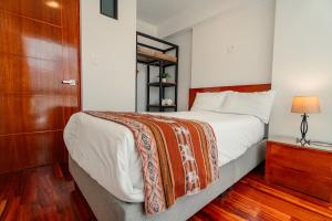 een slaapkamer met een groot bed en een houten kast bij Apartamento con todo cerca en Cusco in Cuzco +20 foto's