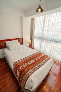 een slaapkamer met een groot bed en een raam bij Apartamento con todo cerca en Cusco in Cuzco