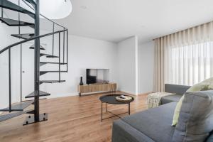 sala de estar con escalera de caracol y sofá en Ermal Terrace, en Vieira do Minho