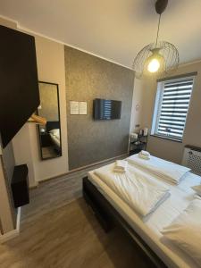 a bedroom with a large bed and a tv on the wall at Suite-Pauli in Hamburg