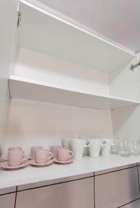 a row of cups and saucers on a shelf in a kitchen at Apartment Club Paraíso in Adeje
