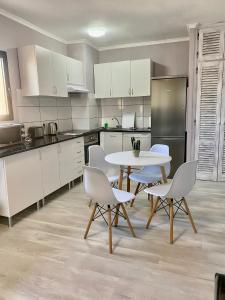 a kitchen with white cabinets and a table and chairs at Apartment Club Paraíso in Adeje