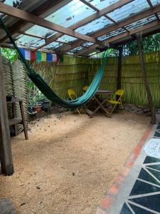a hammock in a shed with a table and chairs at Estudio Embira - Lago Verde in Santarém +16 photos