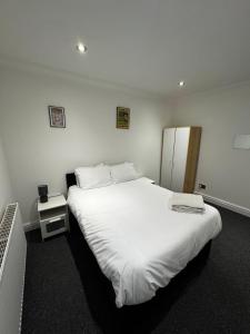 a bedroom with a large bed with white sheets at No 4 AT SANDRINGHAM - LARGE 2 BED NEAR SEFTON PARK in Liverpool