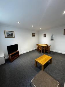 a room with a table and chairs and a television at No 4 AT SANDRINGHAM - LARGE 2 BED NEAR SEFTON PARK in Liverpool