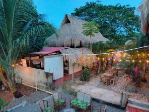 an outdoor restaurant with chairs and tables and a thatched roof at Casa sol palomino in Palomino +16 photos