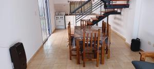 a dining room with a table and chairs and a staircase at Refugio del Este in San Martín