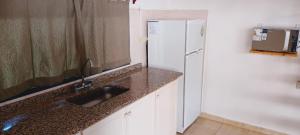 a kitchen with a sink and a refrigerator at Refugio del Este in San Martín