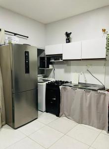 a kitchen with a stainless steel refrigerator and a stove at Acomodação no centro da COP 30 in Belém