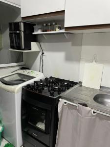 a kitchen with a stove and a sink at Acomodação no centro da COP 30 in Belém