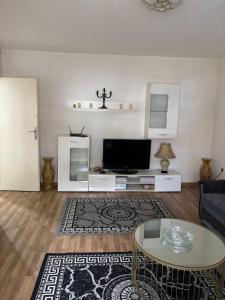 a living room with a tv and a table at Apartman Zaki luxury in Borča