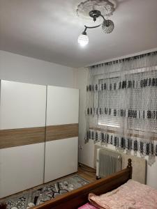 a bedroom with a bed and a dresser and a window at Apartman Zaki luxury in Borča