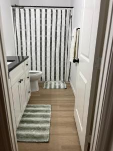 ein Badezimmer mit Toilette und Duschvorhang in der Unterkunft Secluded, Quiet, Cozy, & Modern in Gatesville