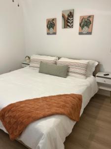 ein Schlafzimmer mit einem großen weißen Bett mit einer braunen Decke in der Unterkunft Secluded, Quiet, Cozy, & Modern in Gatesville