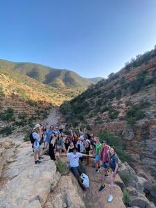 Un grupo de personas de pie en una montaña rocosa en Lumir Surf House, en Tamraght Ouzdar