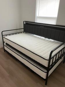 ein Bett mit einem schwarzen Rahmen und einer weißen Matratze in der Unterkunft Secluded, Quiet, Cozy, & Modern in Gatesville