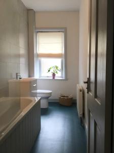 een badkamer met een bad, een toilet en een raam bij Beautiful 3 bed house in central Hebden Bridge in Hebden Bridge
