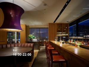 a bar with a long wooden counter and chairs at Hotel The Celestine Ginza in Tokyo