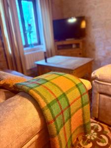 een woonkamer met een bank en een deken bij Casa rural Valdecid in Valdeande