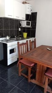 una cocina con una mesa de madera y una estufa en Los Gringuitos - Trapiche, en Trapiche