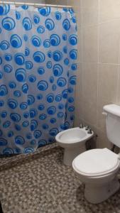 Un baño con inodoro y cortina de ducha en Los Gringuitos - Trapiche, en Trapiche