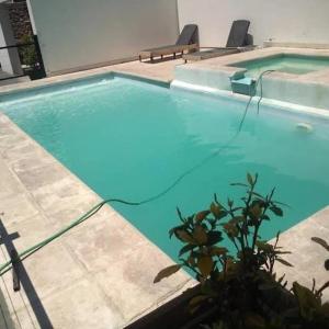 una gran piscina azul con sillas. en Los Gringuitos - Trapiche, en Trapiche