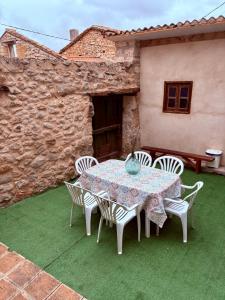 een tafel en stoelen op een groen gazon bij Casa rural Valdecid in Valdeande