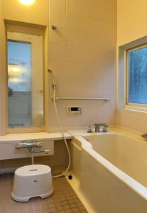 a bathroom with a tub and a toilet and a sink at Cai 芸術の家 in Tsukuba +17 photos