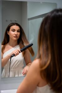 Una mujer cepillándose el cabello frente a un espejo en Alpha Studios Naxos - Adults Only, en Naxos Chora 31 fotos más