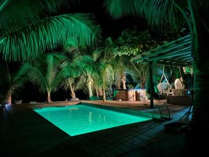 a swimming pool at night with palm trees at Fare Oaoa Haapiti in Moorea