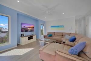 a living room with a couch and a tv at 24 The Esplanade in Woodgate