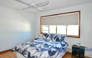 a bedroom with a bed and a ceiling fan at 25 The Esplanade in Woodgate