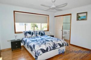 a bedroom with a bed and a ceiling fan at 25 The Esplanade in Woodgate +2 photos